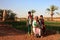 Dakhla Oasis, Egypt - April 2nd of 2015: A bedouin family posing in front of the camera with their own land backwards.