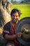 Daklak, Vietnam - Mar 9, 2017: Portrait of minority man in traditional dress knocking a copper gong in forest in Buon Me Thuot