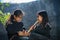 Daklak, Vietnam - Mar 9, 2017: Two Ede ethnic minority little girls learning to play the flute in forest. The Ede have long lived