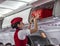 Dalaman, Turkey - June 2016: The flight attendant helps passengers to put things on the luggage rack on the plane.