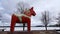 Dalarna horse in front of Saxviken part of lake Siljan in Mora, Sweden