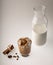 Dalgon coffee in a glass Cup next to a bottle of milk, coffee beans, cinnamon and a bucket on a white background.