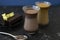 Dalgona coffee and cocoa in glass transparent glasses. Nearby lies a metal spoon with instant coffee, and a chocolate dessert on a