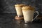 Dalgona coffee in glass cups. Dark moody backgroung with copy space