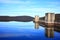 Dam in Australian landscape by blue sky specular reflection in lake