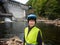 Dam and turbines of a hydroelectric power station with falling water flows and woman in helmet