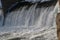 Dam, waterfall. the stream of the river falls from the dam in the winter. icy dam with a strong stream of the river. shiny drops o