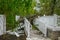 Damage to a white metal fence and guard rail of a deck and ramp from a tree that fell during a storm