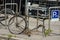 A damaged bike is locked in a bicycle stand.