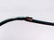 Damaged black electric cord on white background. Dangerous broken electrical cable