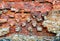 Damaged brick wall of red color. Vintage background, old weathered texture. Shabby surface of grunge masonry. Vintage facade.