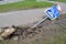 Damaged Broken Traffic Signs With Bus Direction Arrow and Pedestrian Crossing Road are Laying on the ground on a Street