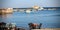 Damaged concrete pier with sunk fisher boat in front of it and blue sky in backgroud