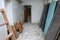 Damaged corridor of an old building with doors and wooden objects on the ground