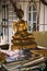 Damaged golden buddha statue sitting behind pile of papers and books