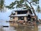 damaged house sinking in to the water in mangrove forest, collapsed old house in the water