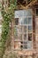 A damaged lattice window at an old hut