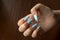 Damaged nail polish of blue color on regrowth nails of the hand. Dark wooden background with space for text. Close-up