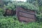 DAMAGED OLD RUSTED GOODS CONTAINER WITH GREEN BACKGROUND