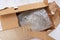 Damaged and torn open cardboard box for transporting things. Top view. Close-up. Bubble wrap keeps things and utensils