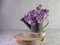 Dame\\\'s rocket flower placed in a rustic metal watering can on natural wood on subway tile