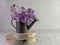 Dame\\\'s rocket flower placed in rustic metal watering can on natural wood on subway tile