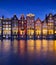 Damrak, Amsterdam, Netherlands. View of houses during sunset. The famous Dutch canals. A cityscape in the evening.