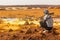 DANAKIL, ETHIOPIA - MARCH 24, 2019: Local Afar armed guard observes Dallol volcanic landscape in the Danakil depression