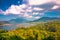 Danau Buyan lake surrounded by lush green forests with a cloudy blue sky overhead in Bali, Indonesia, Asia