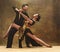 Dance ballroom couple in gold dress dancing on studio background.