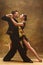 Dance ballroom couple in gold dress dancing on studio background.