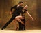 Dance ballroom couple in gold dress dancing on studio background.