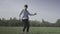 Dance of cheerful carefree Caucasian young man outdoors. Wide shot portrait of happy relaxed dancer dancing on green