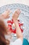 Dance of female hands with mehendi over the altar of candles and rose petals, women practices