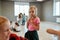 Dance school. Portrait of a little cute girl looking at camera while standing in the dance studio. Group of children