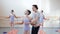 Dance teacher helps girls with exercise at ballet gymnastics class, checking