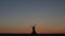 Dancer sexually dances on the sand against the background of a fiery sunset. Silhouettes