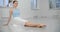 Dancer warms up her legs before rehearsal on the floor of white dance hall, ballet dancer, ballerina in the ballet