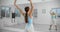 Dancer warms up infromt of the mirror wall in the white bright dance hall before rehearsal, ballet rehearsal, ballerina