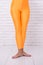 Dancing ballet position of feet. orange. practicing in ballet studio. sport wear fashion. woman in orange leggings on