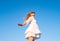 Dancing barefoot. Surprised careless girl jumping up, isolated on sky blue background. Freedom stylish glamorous people