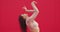 Dancing beautiful girl perform passionate dance on red background. Female professional graceful dancer cool moving hands