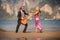 dancing blonde back-view and guitarist on beach