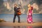 dancing blonde back-view and guitarist on beach