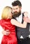 Dancing couple concept. Woman in red dress and man in vest cuddling while dancing. Bearded hipster and attractive lady