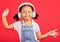 Dancing, energy and child on music headphones, fun radio or loud podcast on isolated red background or studio backdrop