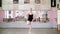 In dancing hall, Young ballerina in black leotard performs grand jete pat de chate , She moving through the ballet class