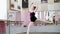In dancing hall, Young ballerina in black leotard performs grand jete pat de chate , She moving through the ballet class