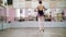 In dancing hall, Young ballerina in black leotard performs tour chaines, She moving through the ballet class elegantly,