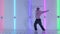 Dancing man young talented street dancer performing freestyle hip hop moves against bright neon lights. Street dancer